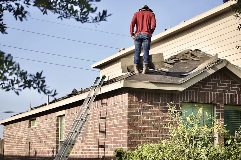 Professional roofer working on a residential roof in Oakland Gardens